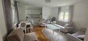 a living room with a couch and a table at Olive Roots Yard House in Trebinje
