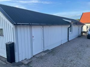 a white building with two doors and a black roof at Vänersborg Linas in Vänersborg +5 photos