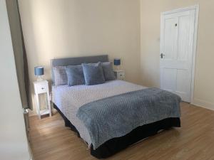 a bedroom with a large bed with blue pillows at cosy room by c in London