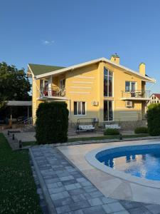a yellow house with a swimming pool in front of it at Aero Hotel in Chişinău