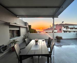 a table and chairs on a patio with the sunset at Sunny Loft in Igoumenitsa