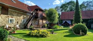una vecchia casa in pietra con un cortile verde di Statek Kloubek a Chabičovice
