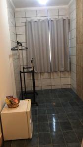 een badkamer met een douche met een gordijn en een doos bij Santa Ana da Ribeira in SantʼAnna do Ipanema