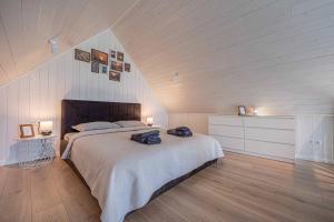a bedroom with a bed with two bags on it at Pondside Cabin - Sauna - Terrace - Near Wake Park in Kiauleikiai