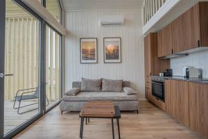 a living room with a couch and a table at Pondside Cabin - Sauna - Terrace - Near Wake Park in Kiauleikiai