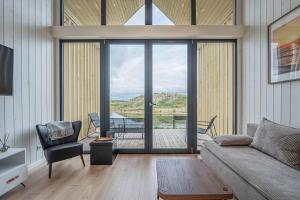a living room with a couch and a view of a deck at Pondside Cabin - Sauna - Terrace - Near Wake Park in Kiauleikiai
