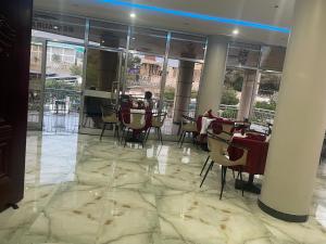 ein Restaurant mit Tischen und Stühlen in einem Gebäude in der Unterkunft Gillu Hotel in Nazrēt + 13 Fotos