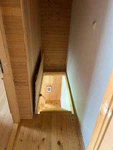 Una pequeña habitación abuhardillada con suelo de madera y escaleras. en Holiday home LOLA, en Žabljak
