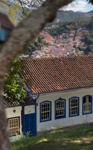 a blue and white house with a city in the background at Acomodação Bicentenária - qrts parte baixa da casa - Rua Casa da Ópera in Ouro Preto