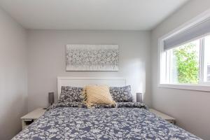 Un dormitorio con una cama y dos ventanas en Cozy 1-Bedroom Retreat in the Heart of Langford, en Victoria
