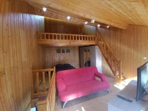 - un salon avec un canapé rose et un escalier dans l'établissement Charmante Maison de Village, à Riotord