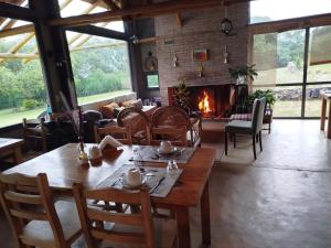 a dining room with a table and a fireplace at Posada del Paraíso-Exclusivo adultos in Las Rabonas +40 photos