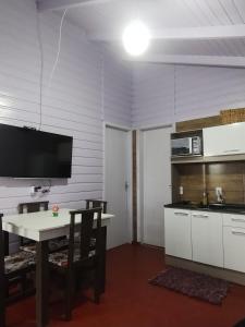 Il comprend une cuisine avec une table et une télévision murale. dans l'établissement Monte Hermon hospedagem, à Bom Jardim da Serra