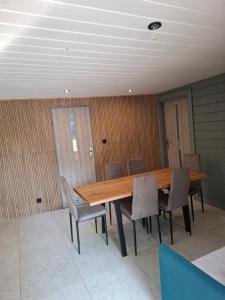 a dining room with a wooden table and chairs at Domek na pensjonatowej 8 in Augustów +3 photos