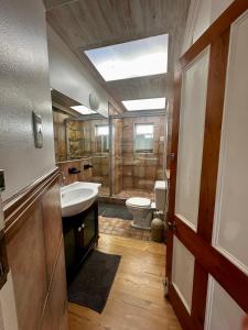 a bathroom with a shower and a sink and a toilet at Corner Cottage on Hill in Mossel Bay +38 photos