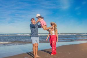 un grupo de tres personas de pie en la playa en Opaba Praia Hotel, en Ilhéus