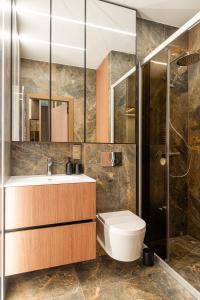 a bathroom with a toilet and a sink and a shower at Sea Waves Apartment in Palanga +16 photos