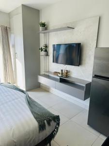 a bedroom with a flat screen tv on a wall at Reamo Suites in Gaborone