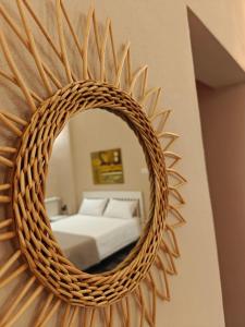 a mirror on a wall with a bed in a room at Elysia Luxury Room con Jacuzzi - Centro Brindisi in Brindisi