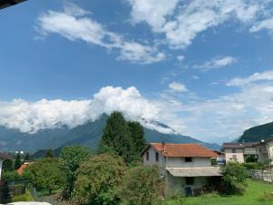 a house in a village with a mountain in the background at Casa Vacanze La Madoneta in Colico