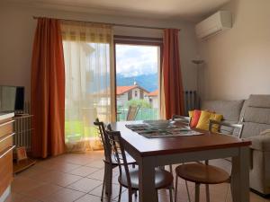 a living room with a table and a window at Casa Vacanze La Madoneta in Colico