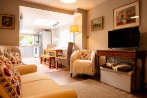 a living room with a couch and a tv and a table at Windlass Cottage in Lymington