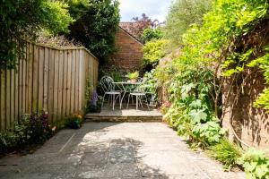 a garden with a table and a fence at Windlass Cottage in Lymington