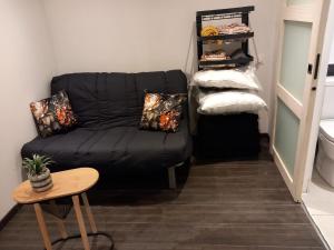 a black couch in a room with a table at Chambre à Pontarlier in Pontarlier