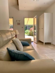 sala de estar con sofá marrón con almohadas en La Clemensane, en Lacoste