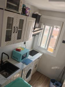 Una pequeña cocina con fregadero y microondas. en Apartamento Torrenueva en playa 4 planta, en Torrenueva