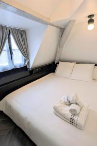 第戎T2 au Cœur Historique de Dijon avec Clim & SmartTV的带窗户的房间里有一张白色的床