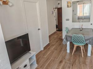 Un comedor con una mesa y un televisor. en Apartamento Torrenueva en playa 4 planta, en Torrenueva