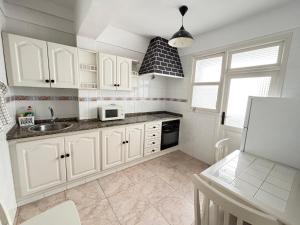 a kitchen with white cabinets and a sink at isacar la real in Santa Cruz de la Palma