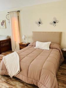 ein Schlafzimmer mit einem großen Bett mit Schmetterlingen an der Wand in der Unterkunft Corazón de Ayrampos APART in San Isidro