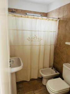 ein Badezimmer mit einem WC-Waschbecken und einem Duschvorhang in der Unterkunft Corazón de Ayrampos APART in San Isidro
