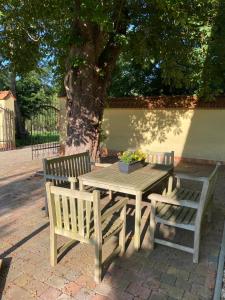 a wooden table and two benches sitting next to a tree at Caravan on farm in Otradovice