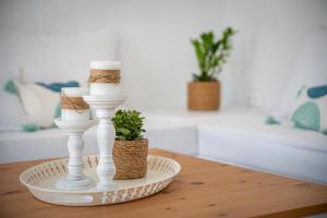 a table with two white candlesticks and a plant at Anthea Suites in Engares +37 photos