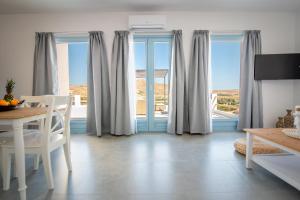 a living room with windows and a table and chairs at Anthea Suites in Engares
