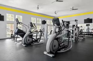 a gym with several cardio machines in a room at Apartment located in the Texas Medical Center near NRG, Discovery Green, Houston Zoo, Museum District in Houston