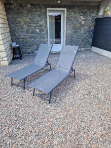 two chairs sitting on top of a gravel patio at Les 3G in Abbeville