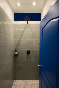 een badkamer met een douche met een blauwe deur bij Surfside El Tunco in Tamanique