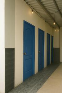 een rij blauwe deuren in een gang bij Surfside El Tunco in Tamanique