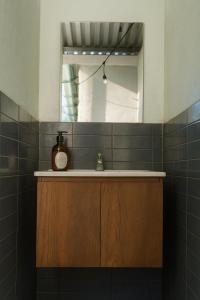 een badkamer met een wastafel en een spiegel bij Surfside El Tunco in Tamanique