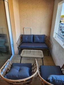 eine Veranda mit einem Sofa und Stühlen auf einem Balkon in der Unterkunft port grimaud in Grimaud