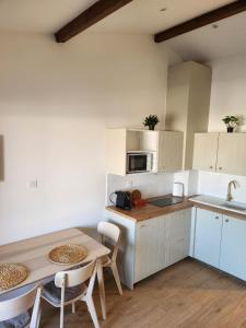 eine Küche mit weißen Schränken und einem Tisch und einer Spüle in der Unterkunft port grimaud in Grimaud