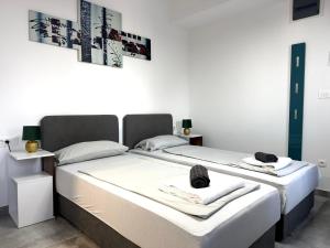 two beds sitting next to each other in a bedroom at Apartments Jelović in Sinj