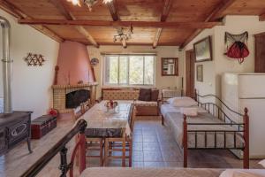 a living room with a table and a fireplace at Nicola's House in Tsivarás