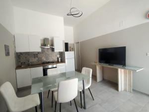 a kitchen with a glass table and white chairs at Casa Vacanza Dante Alighieri, B in Moscufo