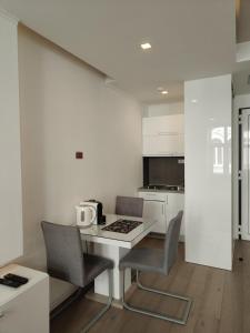 a white kitchen with a table and chairs and a counter at Central Point Privilege Apartments in Sarajevo +23 photos