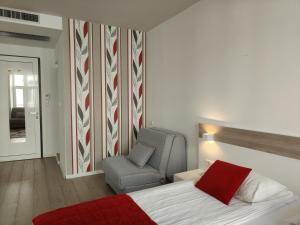 a bedroom with a bed and a chair and a flag at Central Point Privilege Apartments in Sarajevo